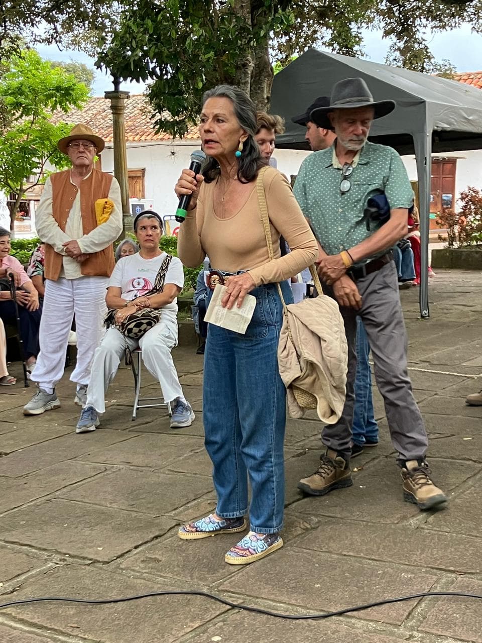 Vocera de la comunidad hablando en el micrófono durante la protesta