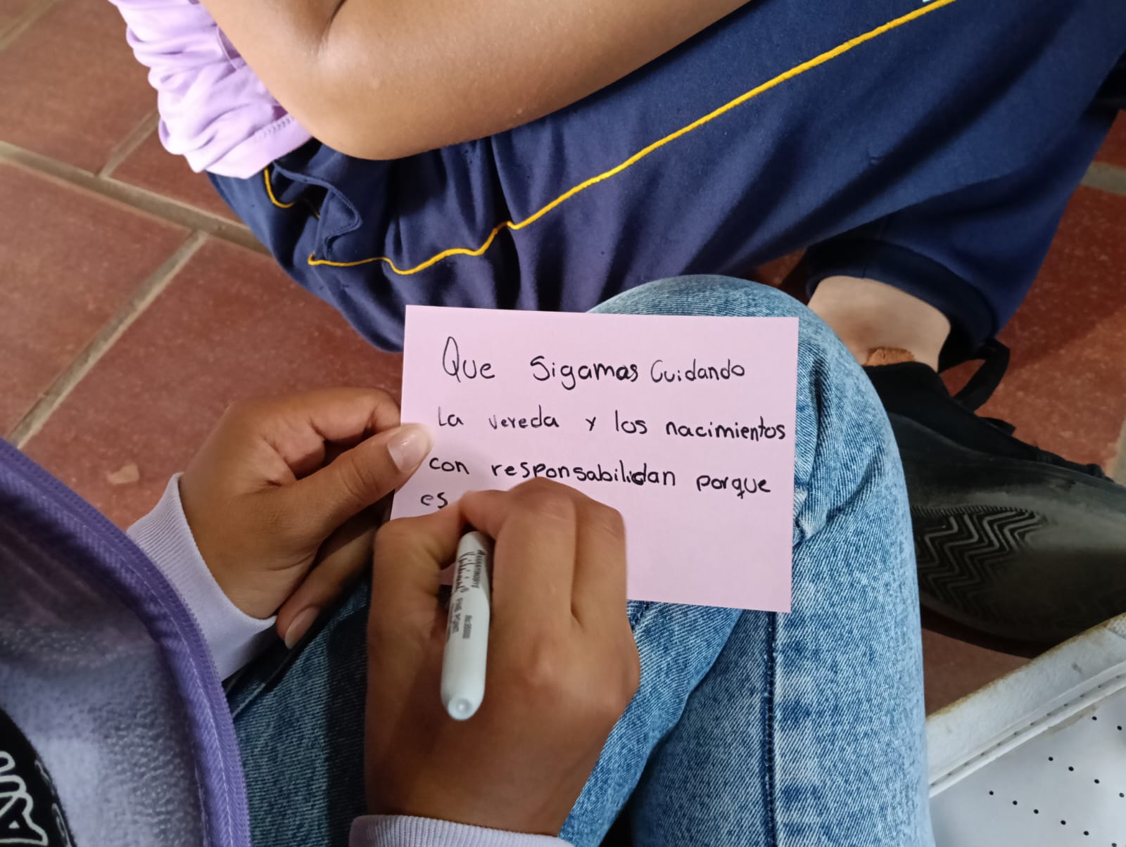 Estudiantes escribiendo en cartulina durante taller